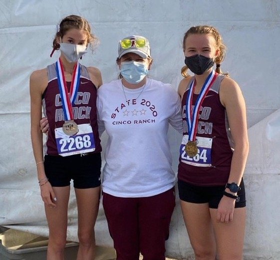 Cinco Ranch seniors Sophie Atkinson, left, and Heidi Nielson, right, pose with coach Dana Mathis after finishing second and third, respectively, at the UIL Class 6A state meet on Tuesday afternoon in Round Rock.